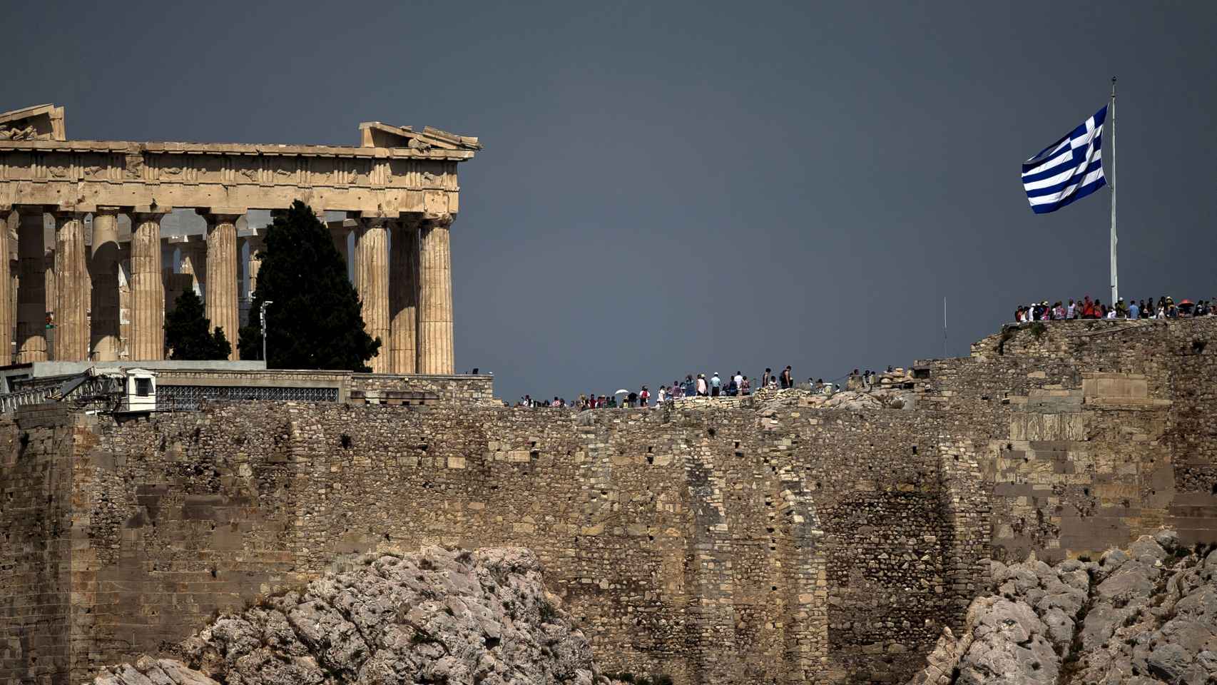 La bandera griega ondea junto al Partenón en Atenas.