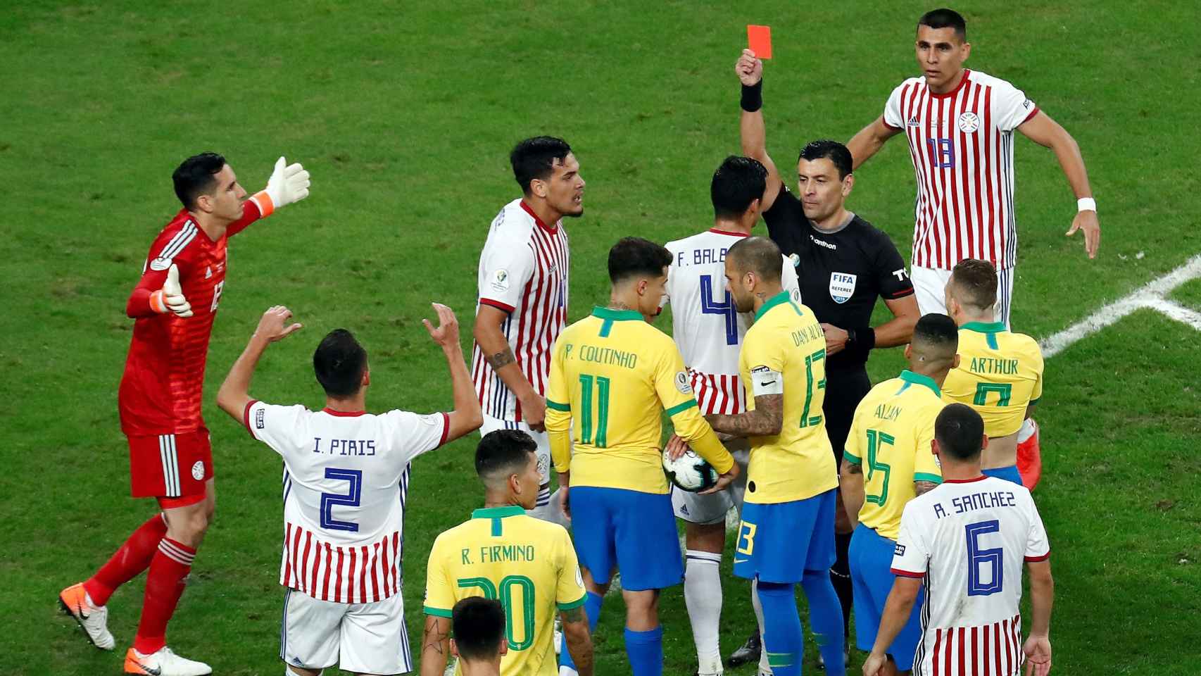 Roberto Tobar entre los jugadores de Brasil y Paraguay