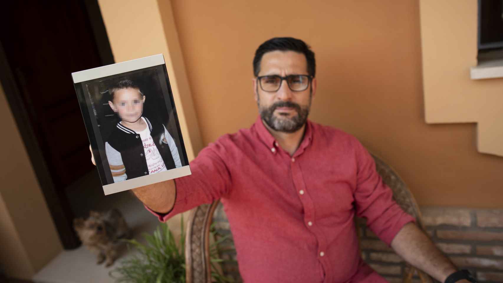 Jesús Bernabé sosteniendo una de las numerosas fotos que tiene de su hijo en su casa.