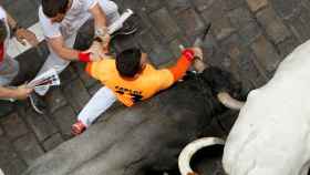 Carlos agarra del pitón al toro durante los encierros de San Fermín.