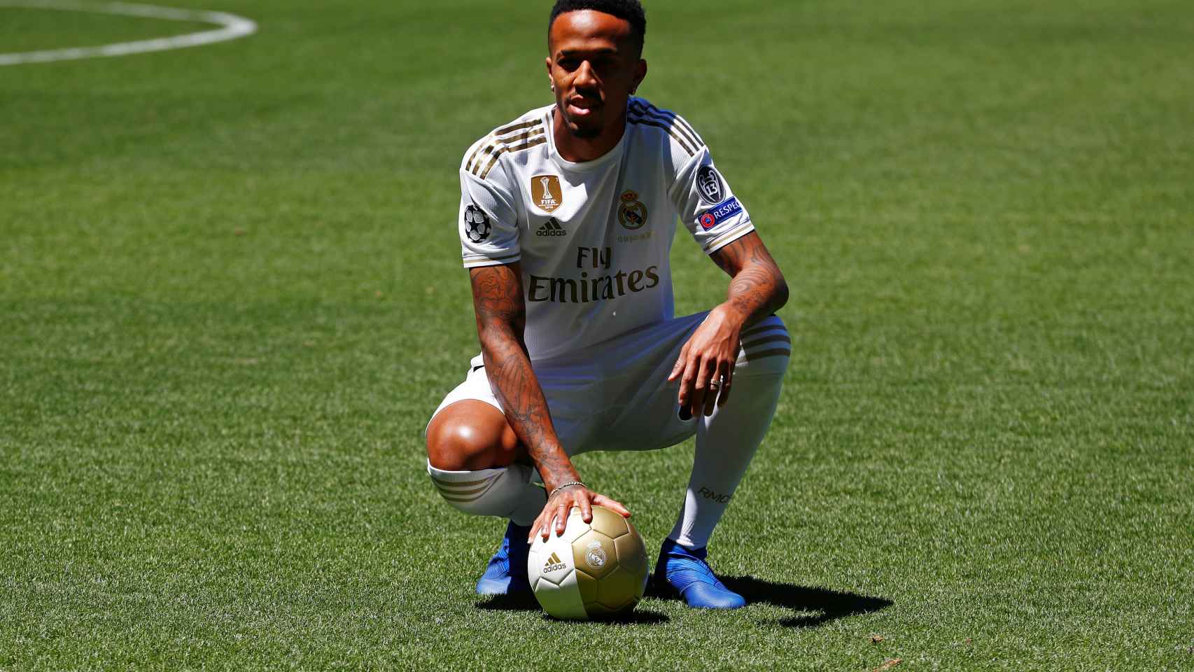 Eder Militao posa con la camiseta del Real Madrid en el césped del Santiago Bernabéu
