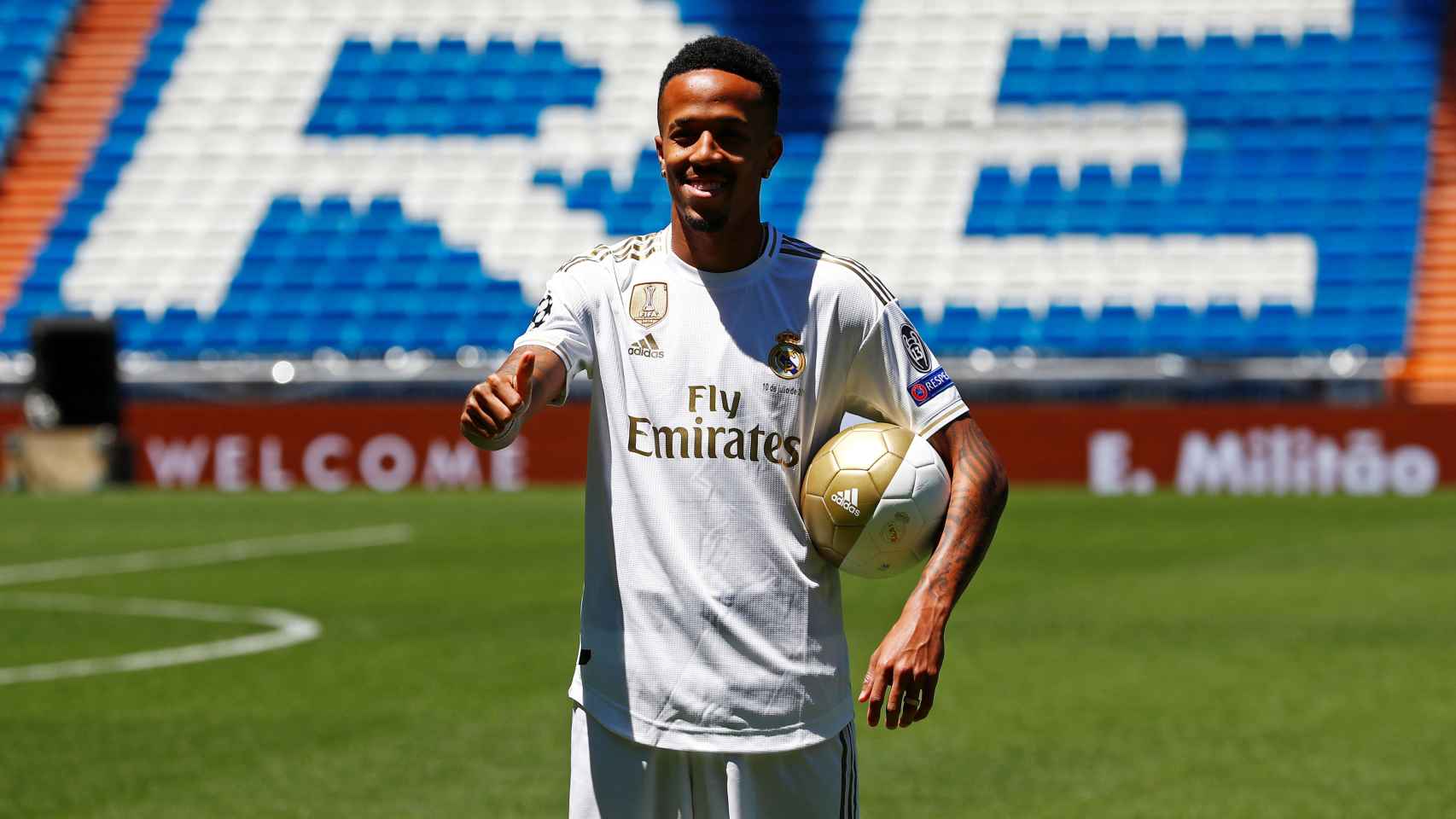 Eder Militao posa con la camiseta del Real Madrid en el césped del Santiago Bernabéu
