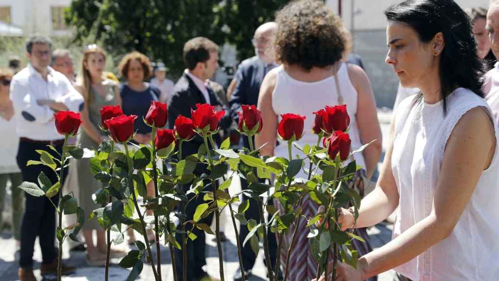 Marta Buesa, (d) hija de Fernando Buesa asesinado por ETA, coloca un rosa este jueves en el homenaje del Ayuntamiento de Ermua a Miguel Ángel Blanco con motivo del 22 aniversario de su secuestro y asesinato por ETA.