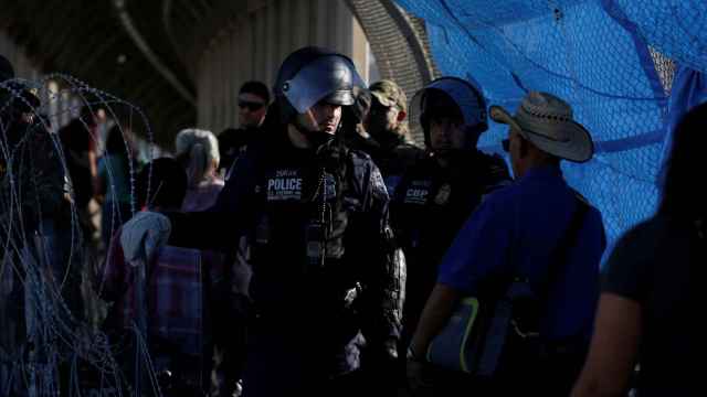 La policia junto a los inmigrantes en Paso del Norte.