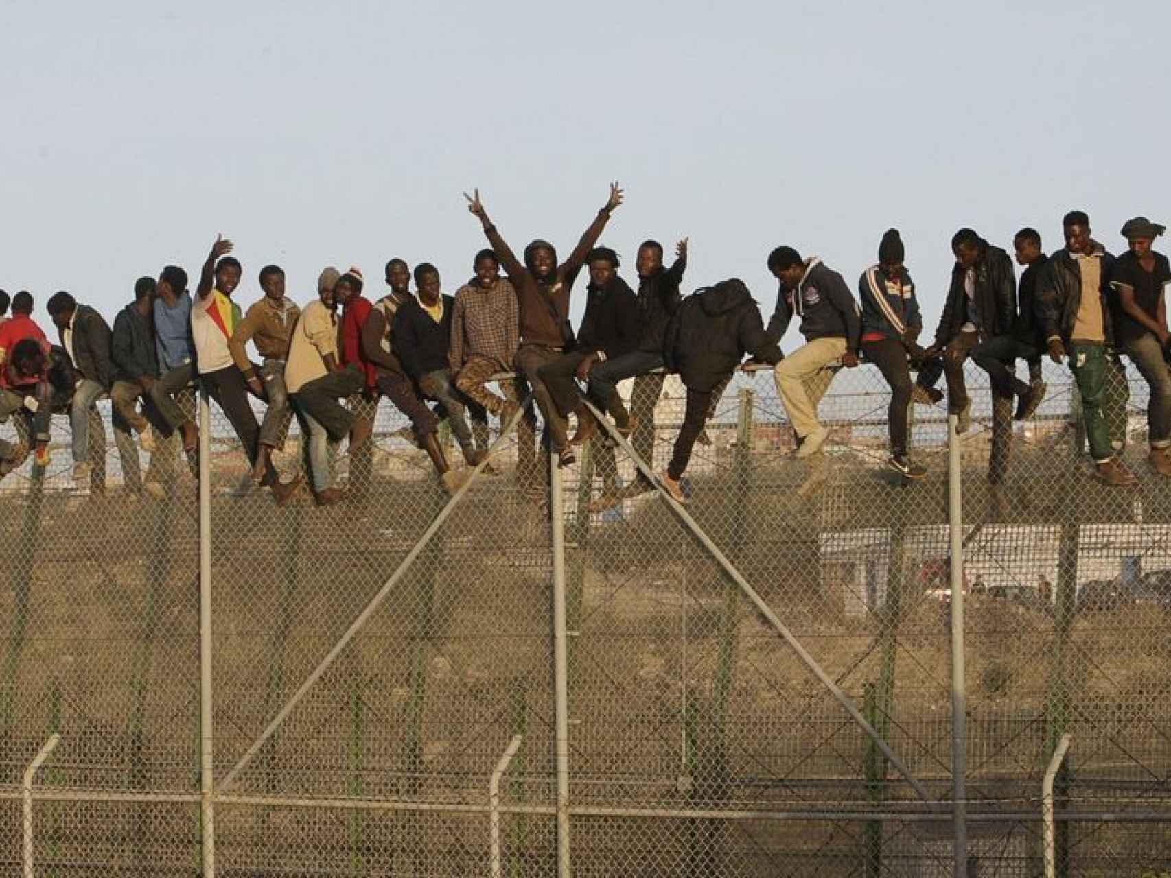 Inmigrantes encaramados a la valla fronteriza de Melilla.