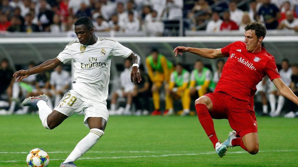 Vinicius dispara a portería con el jugador del Bayern delante