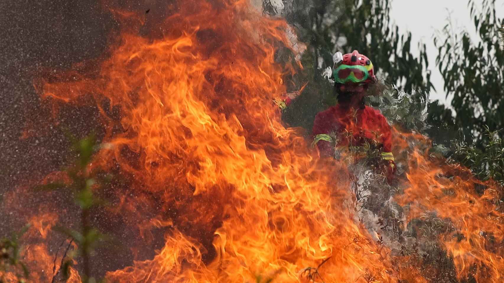 Un bombero trata de extinguir las llamas en un incendio en Maçao, Portugal.