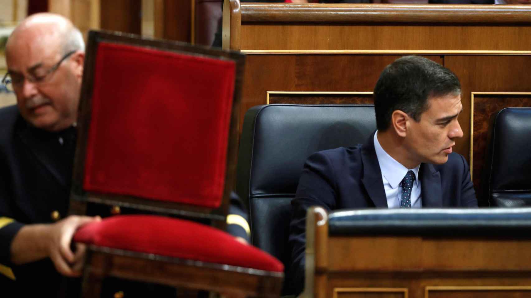 Un ujier del Congreso se lleva una silla en presencia del candidato socialista, Pedro Sánchez.
