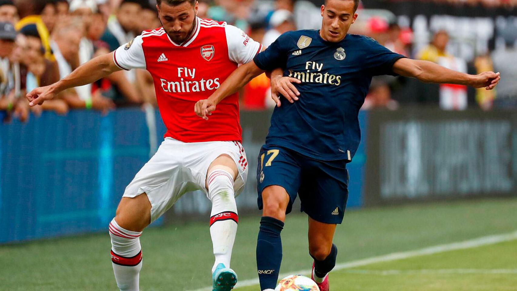 Lucas Vázquez pelea por el balón con un jugador del Arsenal
