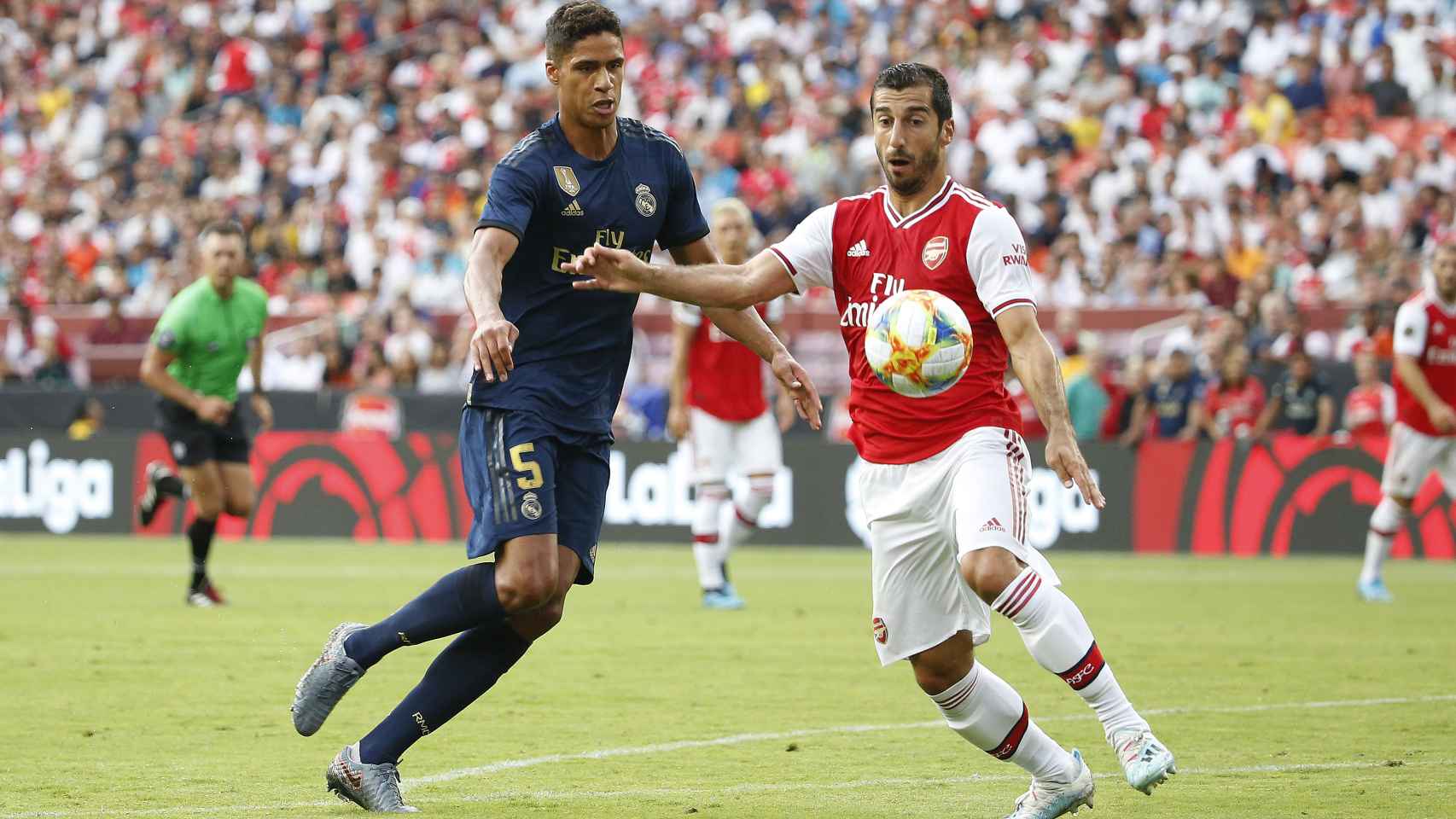 Varane pelea por el balón con un jugador del Arsenal