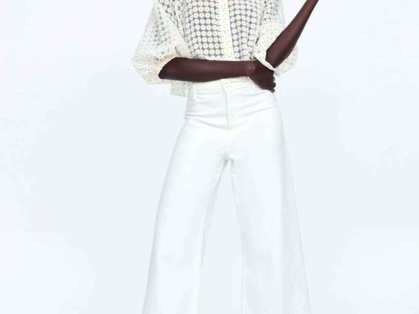Modelo de Zara luciendo la blusa blanca de estampado de margaritas.