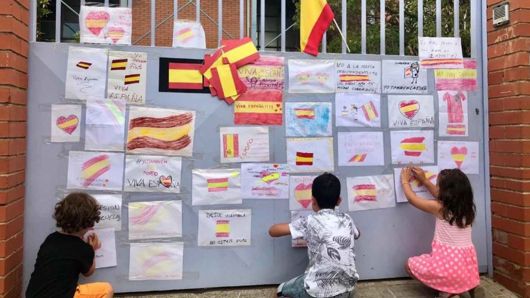 La puerta del colegio se llenó de banderas de España en apoyo a la niña.