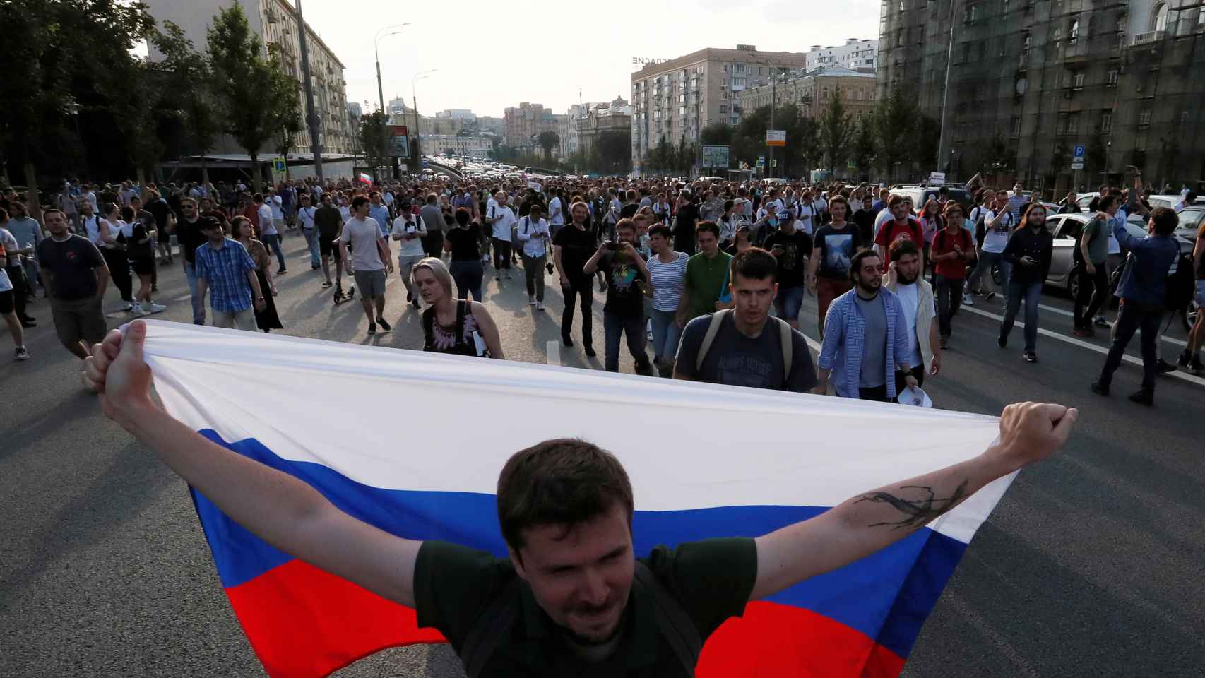 Un hombre porta una bandera rusa en la manifestación.