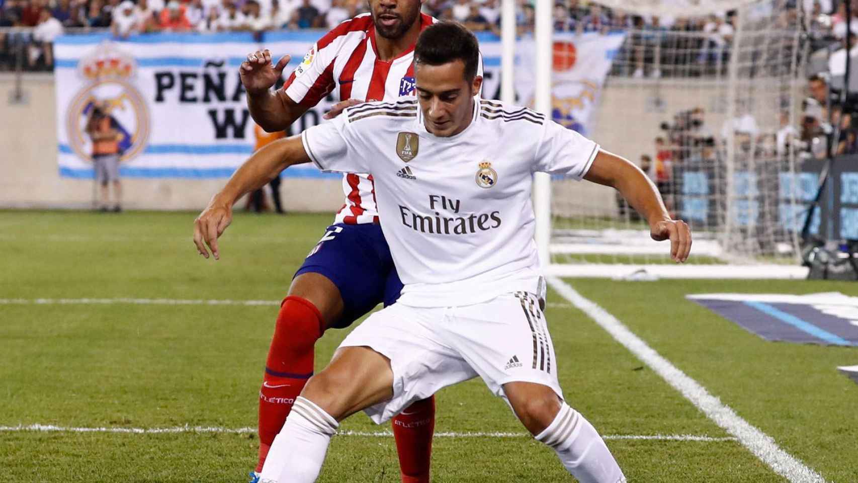 Lucas Vázquez protege el balón de un jugador del Atlético