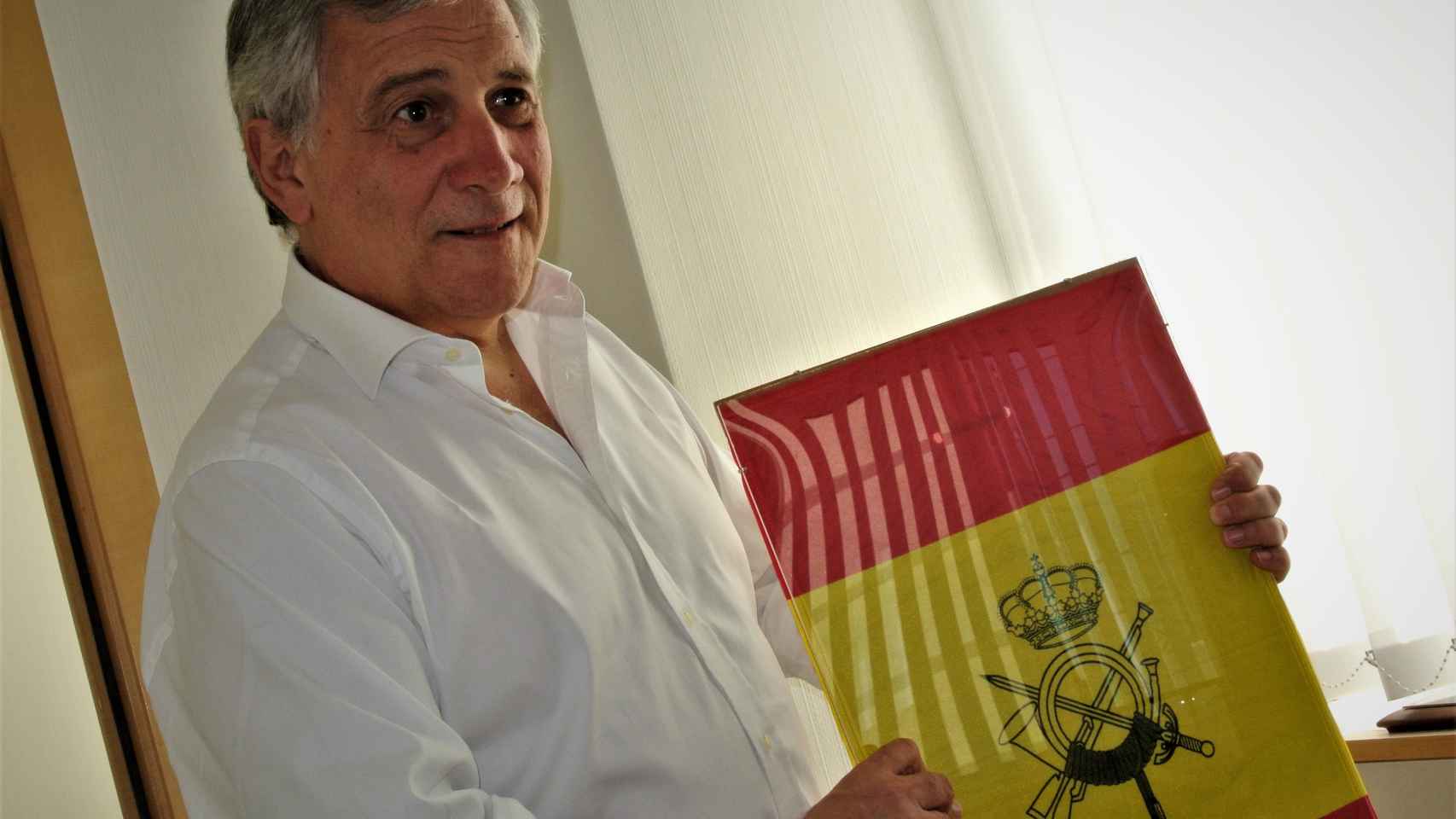 Antonio Tajani muestra la 'bandera de percha' que le regaló la Escuela de Infantería del Ejército español.