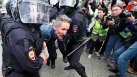 Un manifestante es detenido por policías rusos en Moscú.