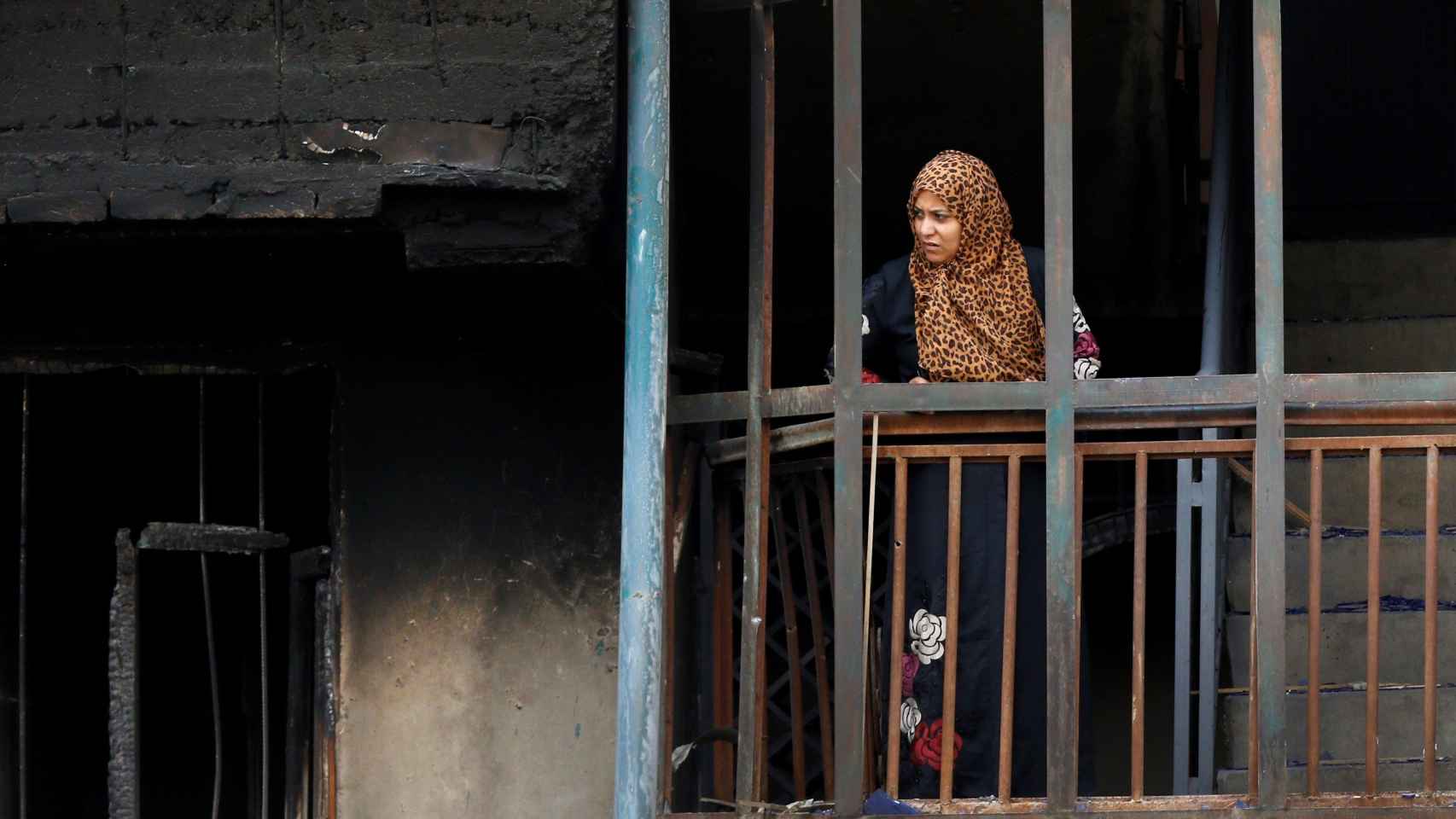 Una mujer observa un edificio destrozado tras un atentado.