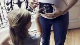 Una mujer embarazada con una ecografía de su bebé.