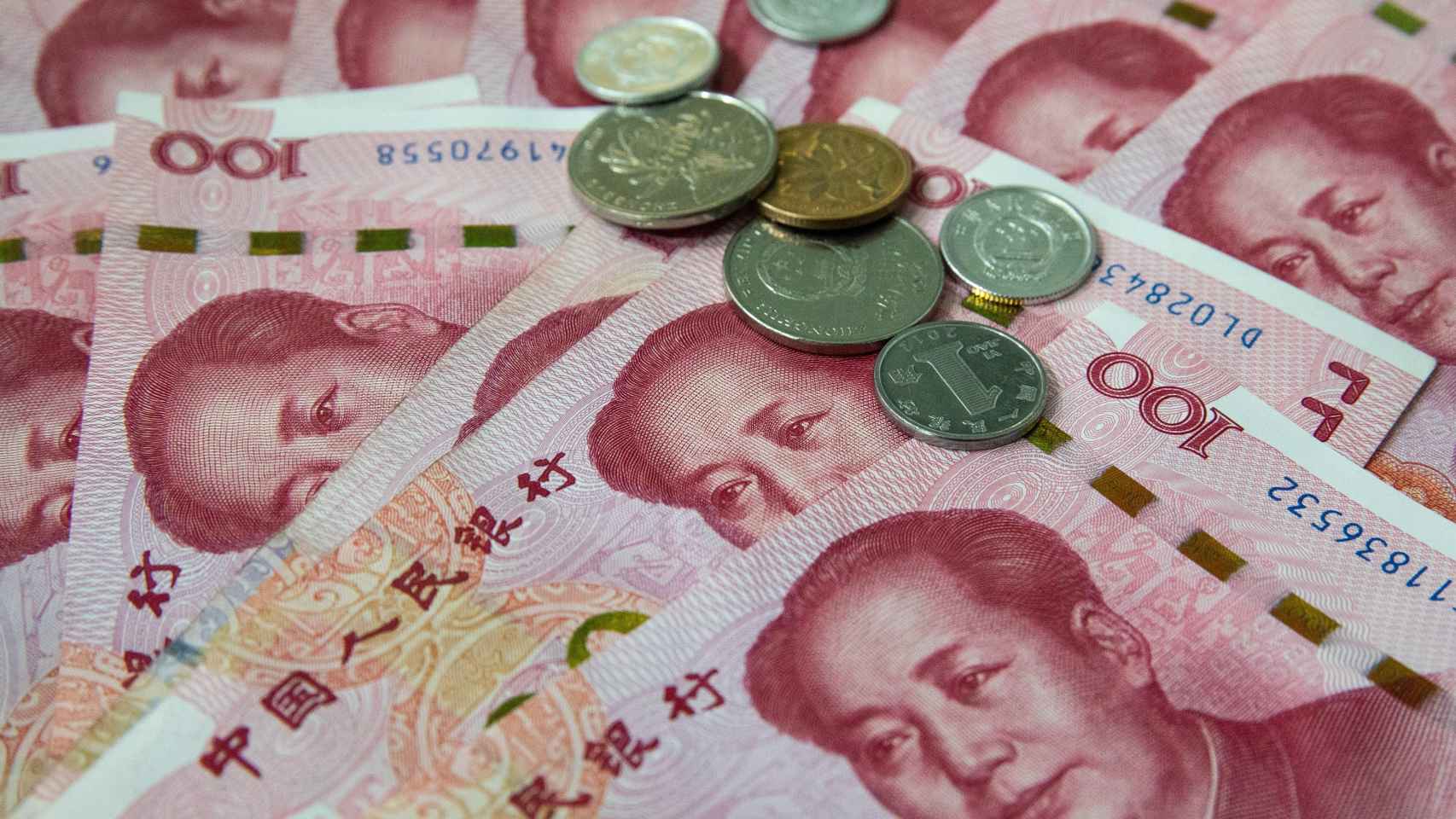 Billetes y monedas chinos de 100 yuanes.