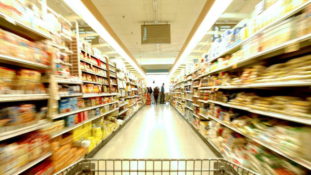 Los pasillos de un supermercado con estanterías repletas de productos.