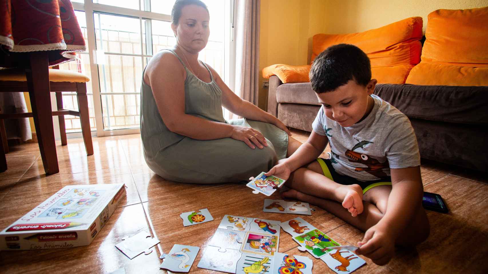 Joaquín junto a su madre Yolanda jugando con un puzzle.