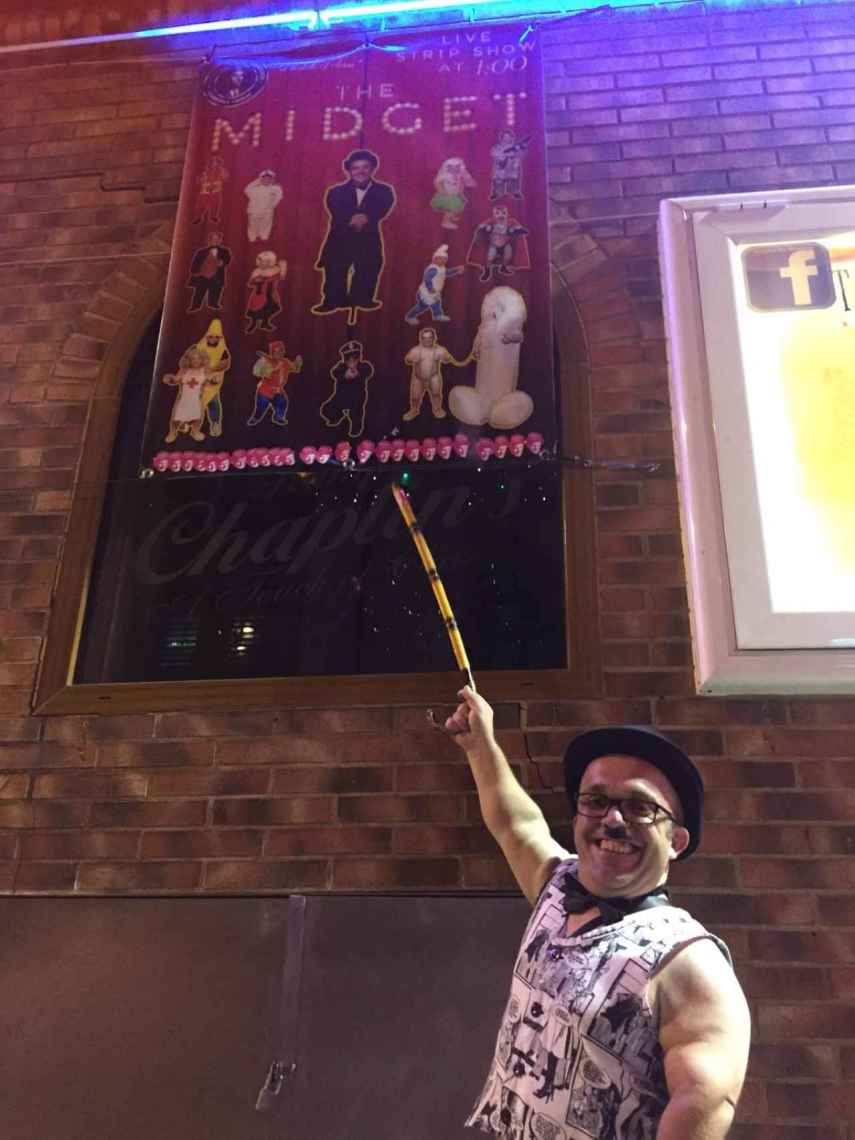 Toni señala el cartel que hay en la puerta del Chaplin promocionando su espectáculo