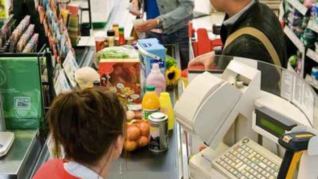 Una mujer pagando en el supermercado.