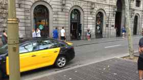 Un taxi pasa por la puerta de Starbucks en Barcelona.