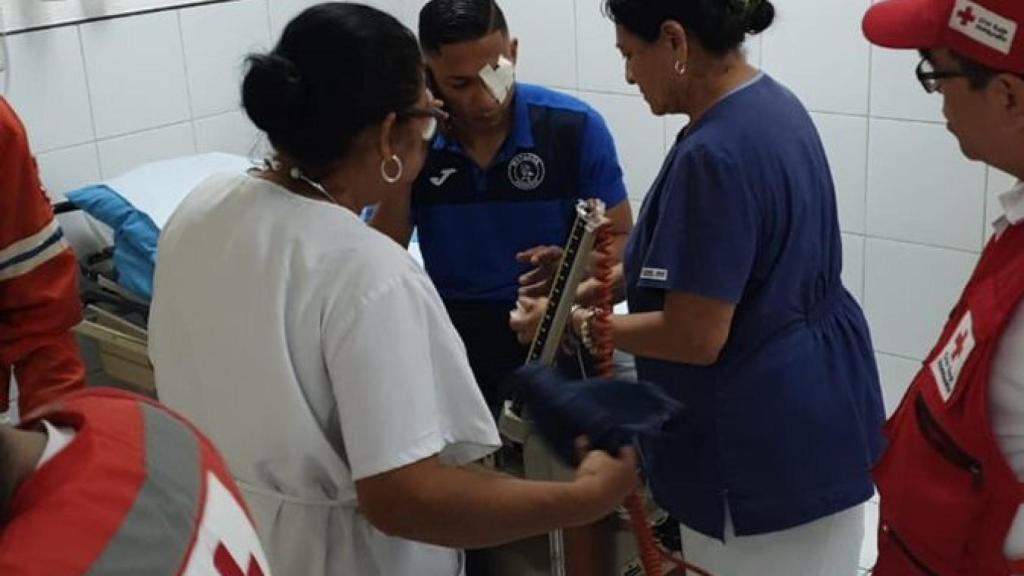 Un jugador del Motagua es atendido tras el vandálico ataque al autobús del equipo. Foto: Twitter (@MOTAGUAcom)