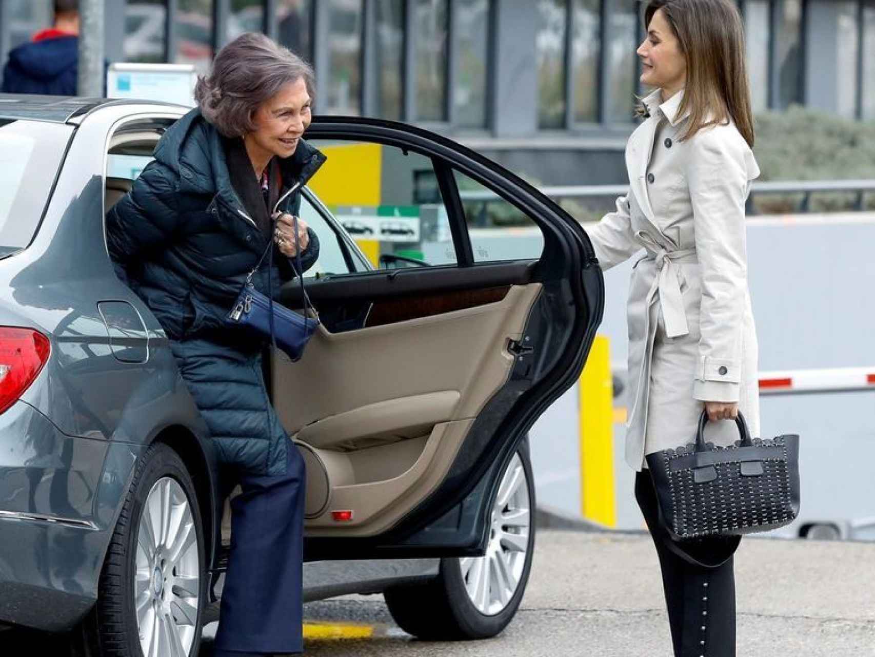 La reina Letizia abre la puerta del coche a la reina Sofía.