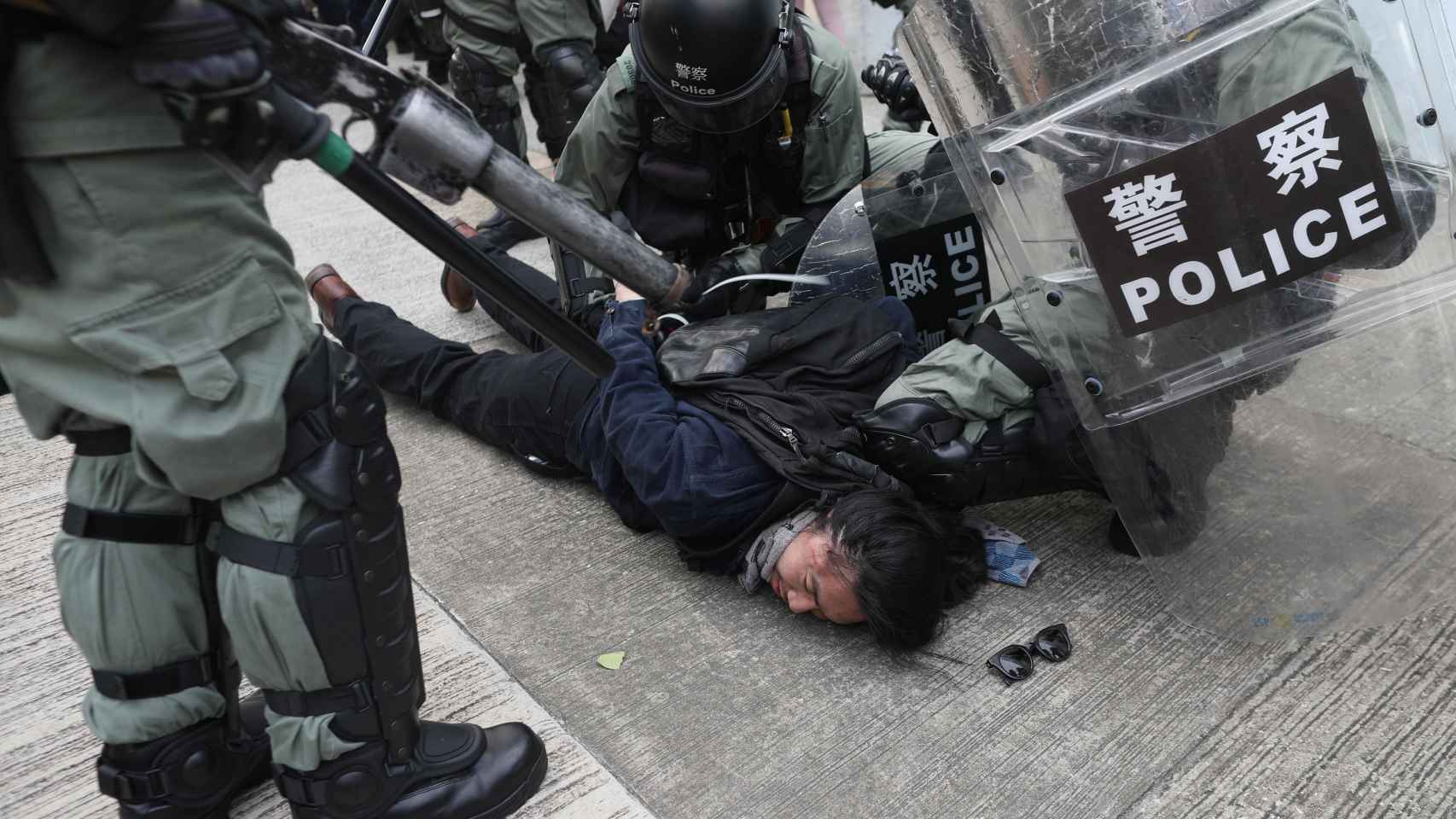 Policías reducen a un manifestante.