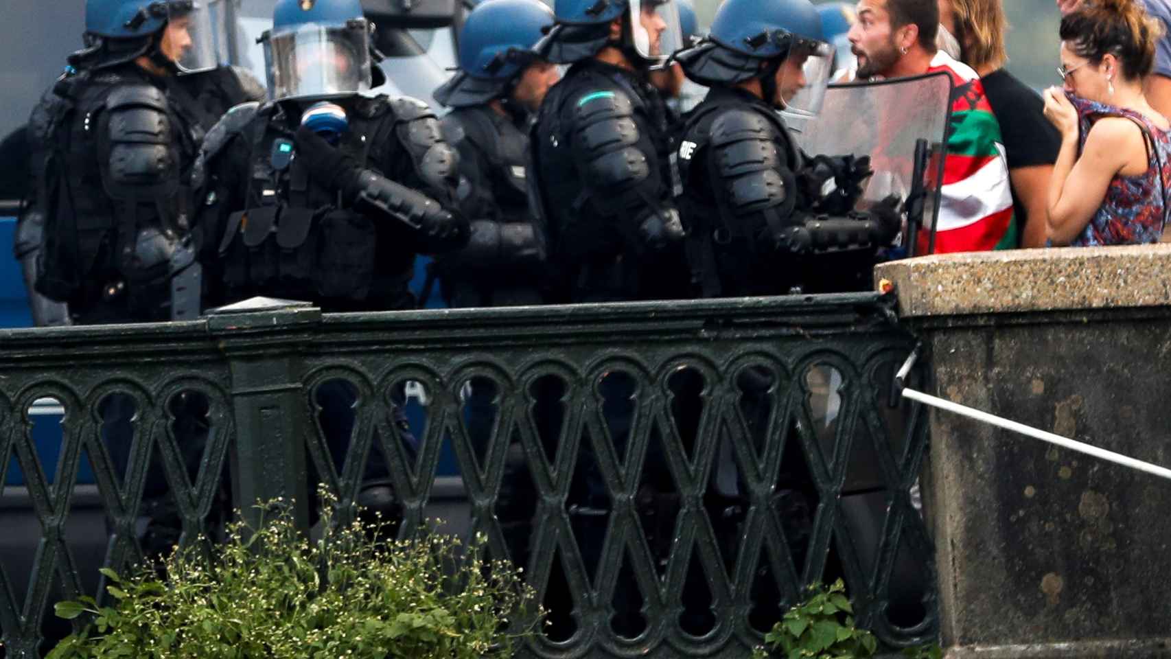 Policías franceses intentan evitar el paso de los manifestantes.