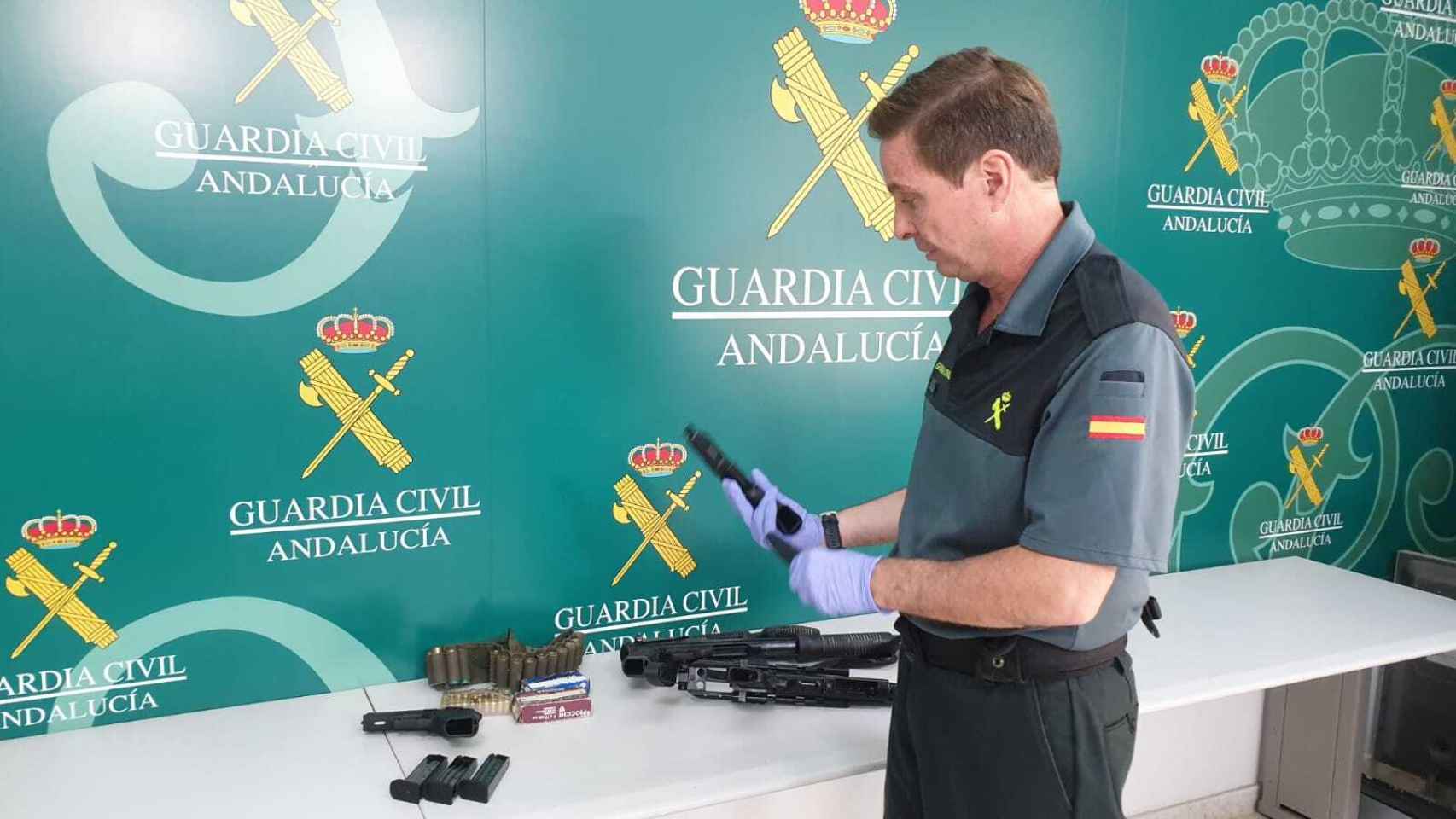 Un agente de la Guardia Civil muestra una de las diez armas intervenidas al clan de Ginés González.