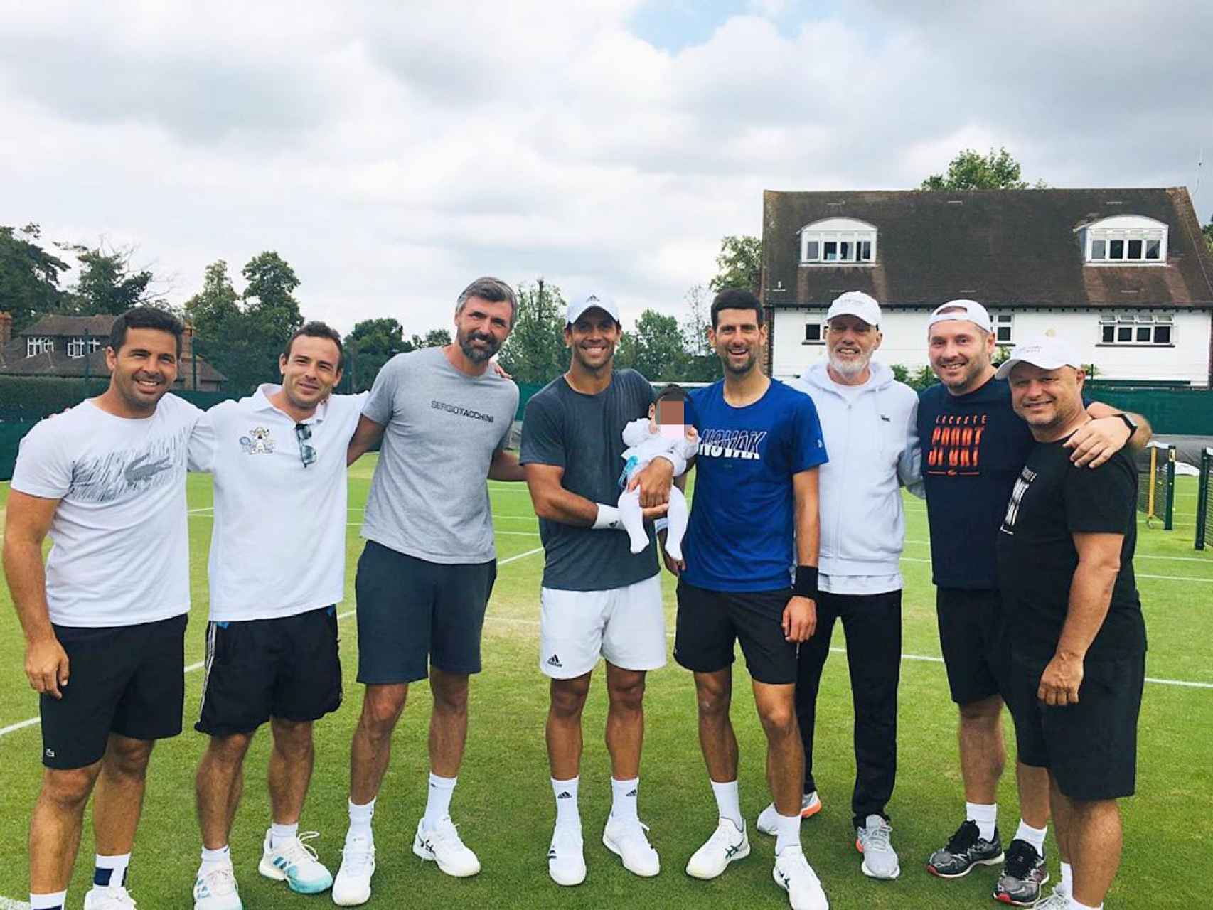 Fernando Verdasco con algunos de sus compañeros y su hijo Miguel en brazos durante el torneo de Wimbledon.