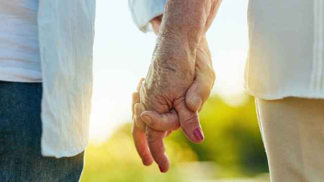 Una pareja de ancianos se toma de la mano.