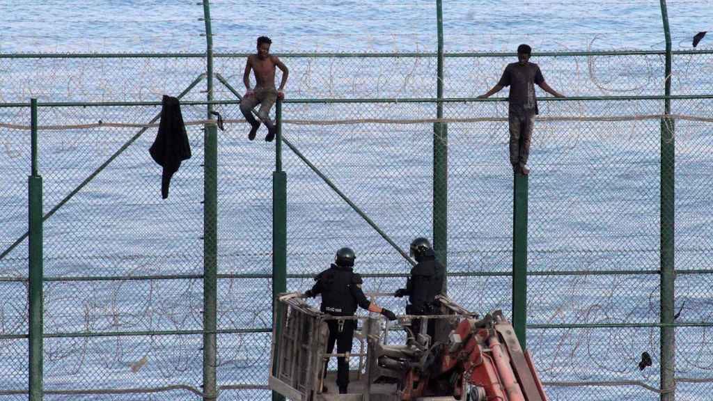 Dos inmigrantes subsaharianos permanecen este viernes en la valla fronteriza de Ceuta.