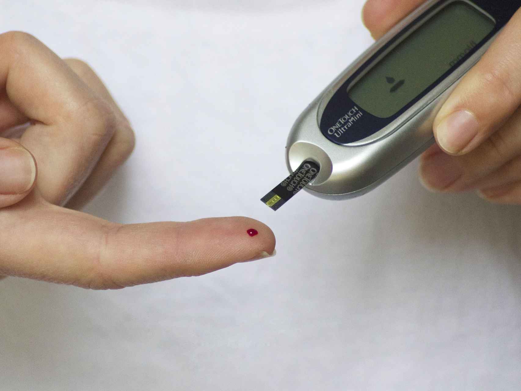 Una persona controla con una máquina sus niveles de glucosa en sangre.