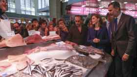 Los reyes Felipe y Letizia admiran pescados en un mercado de Valencia.