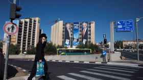 Un hombre pasa junto a una valla publicitaria de la campaña de Likud.