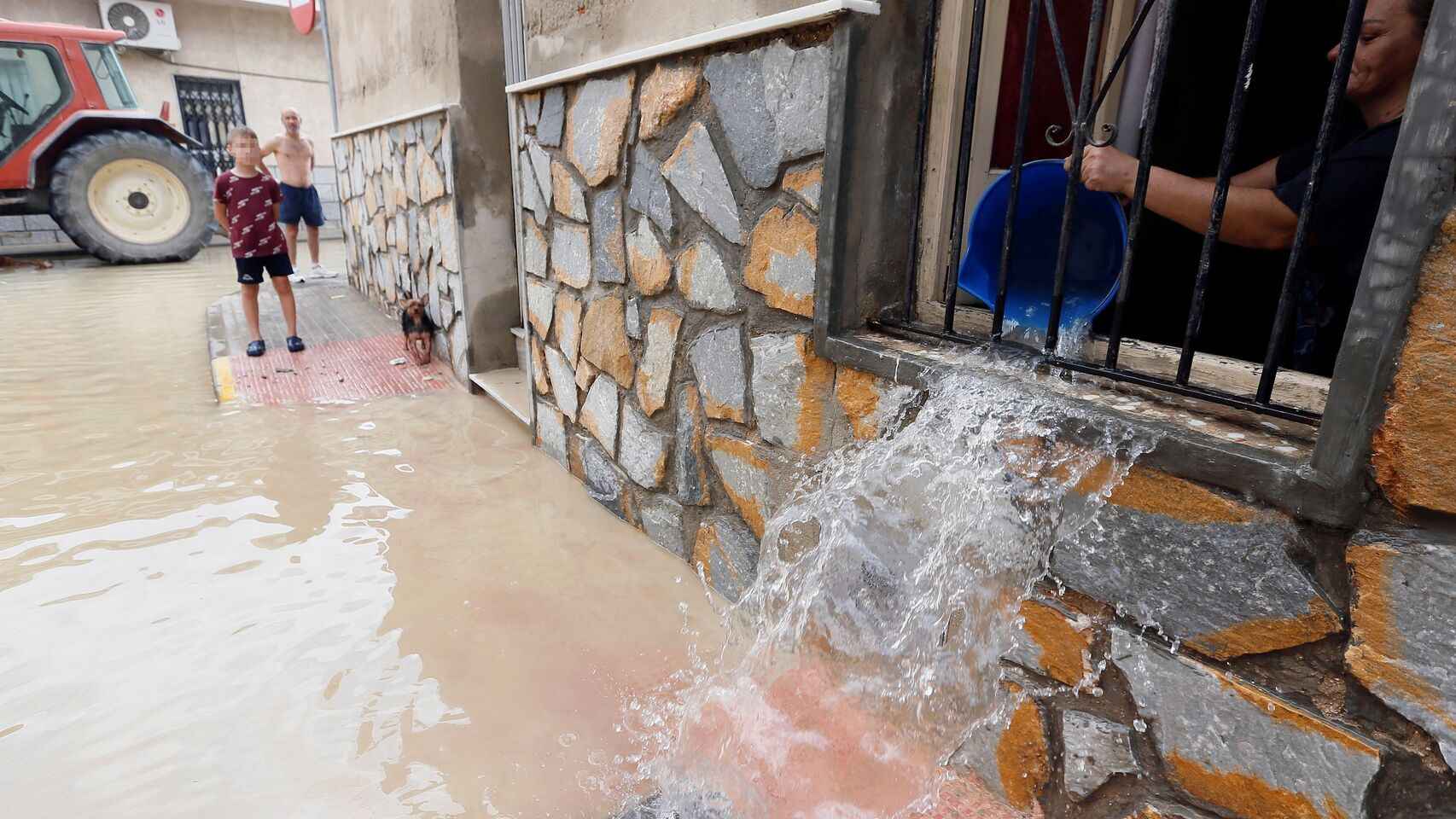 Una mujer achica el agua en su casa en Dolores (Alicante).
