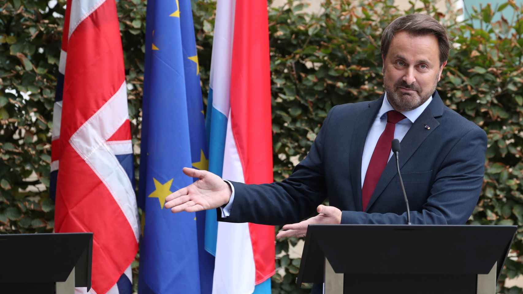 El primer ministro luxemburgués, Xavier Bettel, señala el lugar que tendría que haber ocupado Johnson en la rueda de prensa