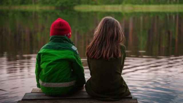 Dos niños contemplan un lago.