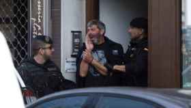 Agentes de la Guardia Civil acompañan a uno de los nueve detenidos durante el registro de un domicilio en Sabadell.