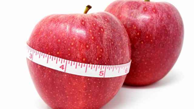 Una cinta métrica alrededor de una manzana roja.