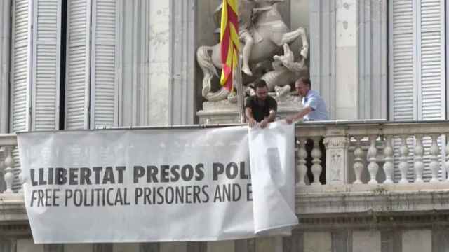 Momento en el que retiran la pancarta en apoyo a los políticos presos de la fachada de la Generalitat.