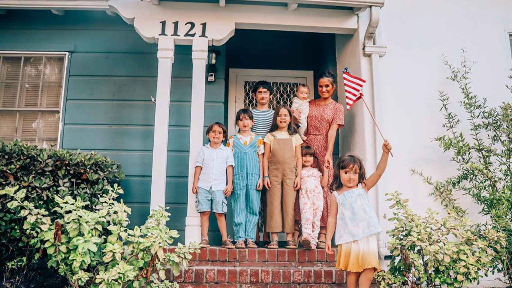 Verdeliss junto a sus siete hijos en la puerta de su casita alquilada en California.