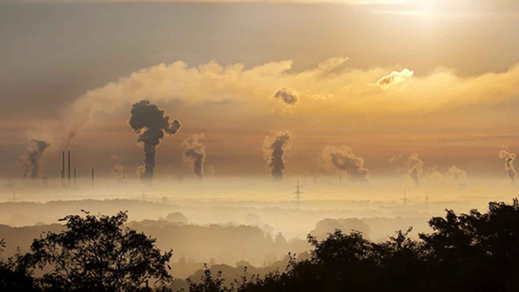 Un paisaje con fábricas emitiendo gases a la atmósfera.