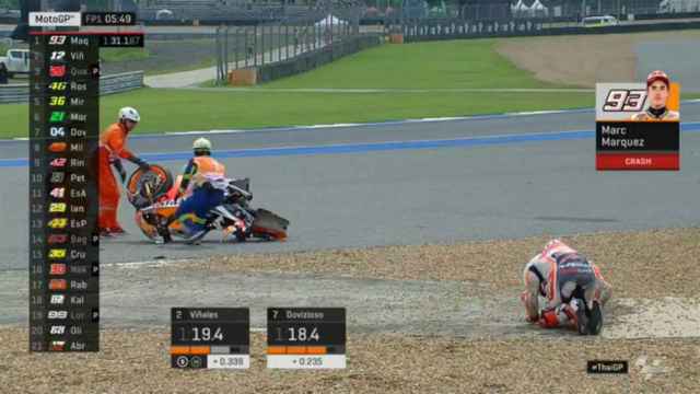 Marc Márquez se duele sobre la grava del circuito de Buriram, con su moto desintegrada.