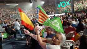 Una señera valenciana entre banderas de España y de Vox, en las gradas de Vistalegre Plus Ultra.