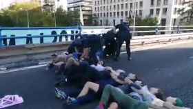 Agentes retirando a los activistas que habían cortado el puente de la Castellana.